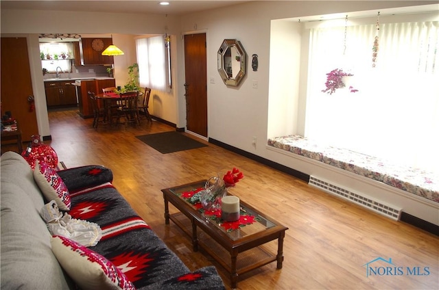 living room featuring visible vents, baseboards, and wood finished floors