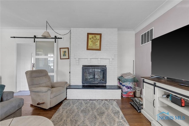 10243 S Dixie Hwy, Portage, OH 43451 - living area featuring a fireplace, a barn door, dark wood finished floors, visible vents, and ornamental molding