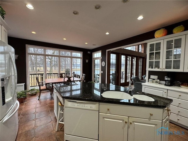 kitchen featuring a sink, white cabinetry, recessed lighting, white appliances, and glass insert cabinets