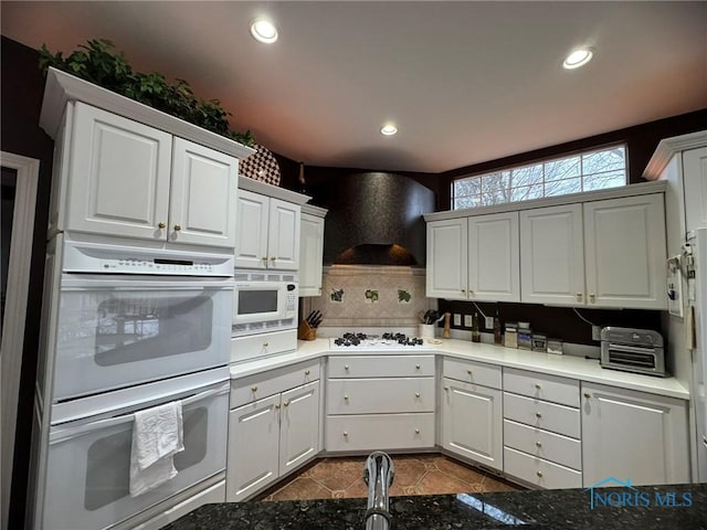 kitchen featuring recessed lighting, white appliances, and exhaust hood