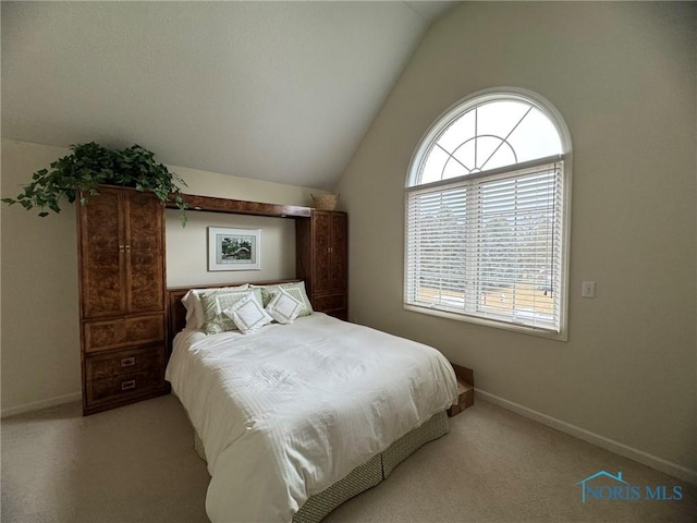 bedroom with vaulted ceiling, light colored carpet, and baseboards