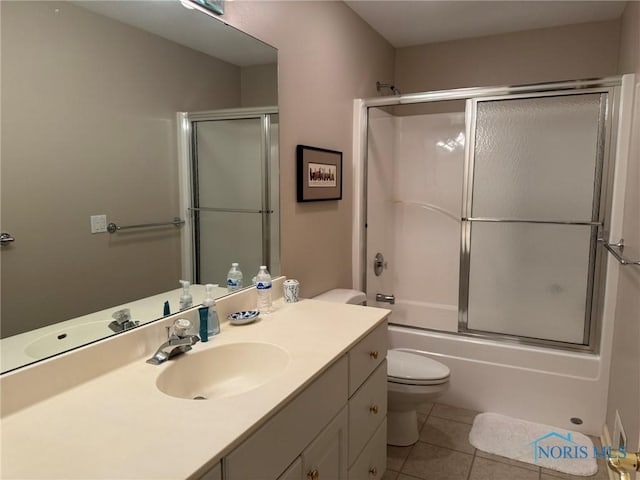 full bathroom with vanity, tile patterned floors, toilet, and enclosed tub / shower combo