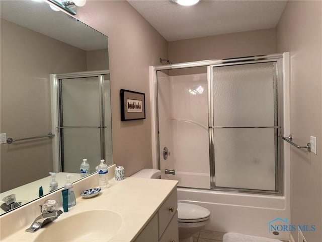 full bath featuring tile patterned flooring, toilet, vanity, and shower / bath combination with glass door