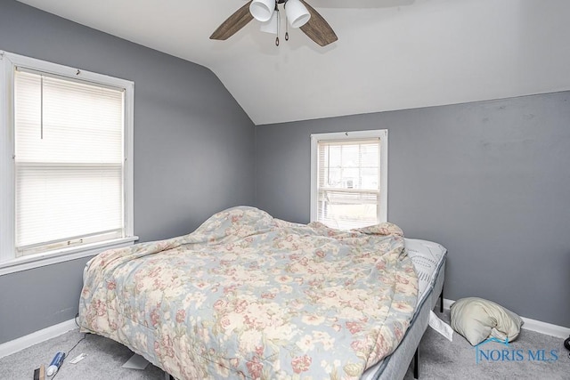 carpeted bedroom featuring vaulted ceiling, baseboards, and ceiling fan