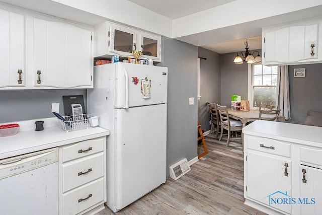 kitchen with visible vents, light countertops, light wood-type flooring, white appliances, and white cabinetry