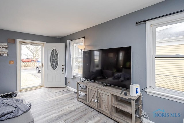 foyer entrance with baseboards and light wood-type flooring