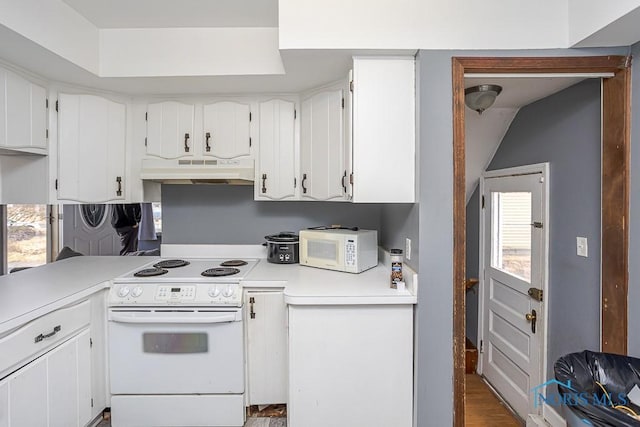 kitchen with white appliances, white cabinets, light countertops, and under cabinet range hood