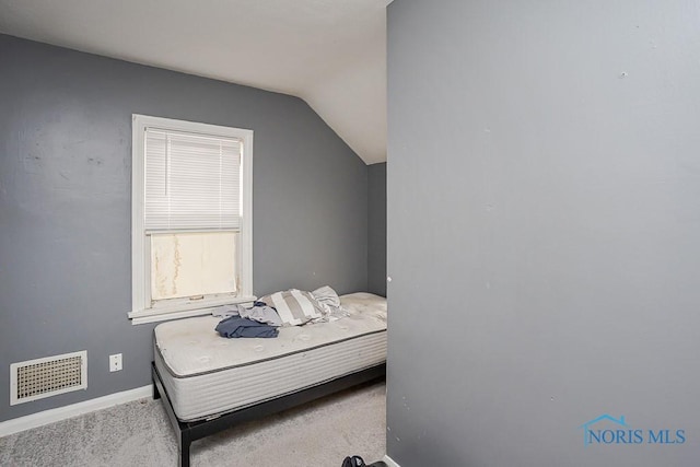 bedroom with lofted ceiling, carpet, visible vents, and baseboards