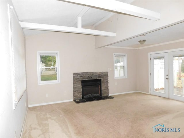 unfurnished living room with french doors, carpet floors, a stone fireplace, baseboards, and vaulted ceiling