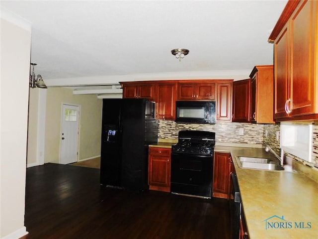 kitchen featuring dark wood-type flooring, black appliances, a sink, backsplash, and reddish brown cabinets