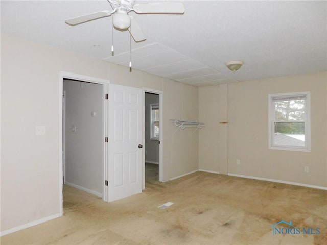 carpeted spare room with baseboards and ceiling fan