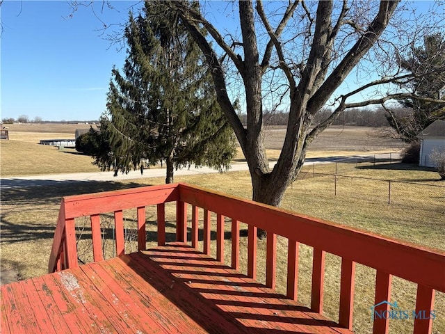 deck featuring a yard, a rural view, and fence