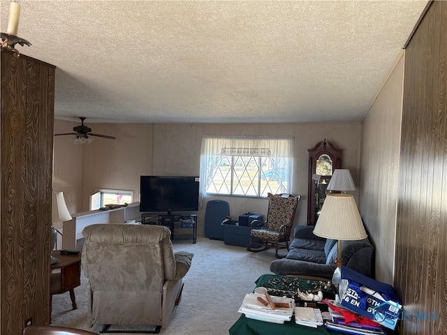 carpeted living area with a ceiling fan and a textured ceiling