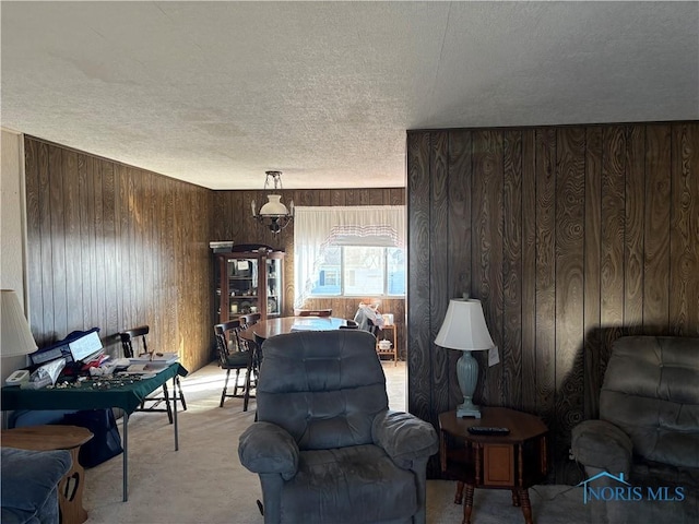 living area featuring wooden walls and a textured ceiling