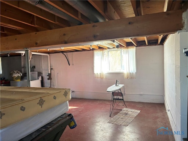 basement with washer and dryer and concrete block wall