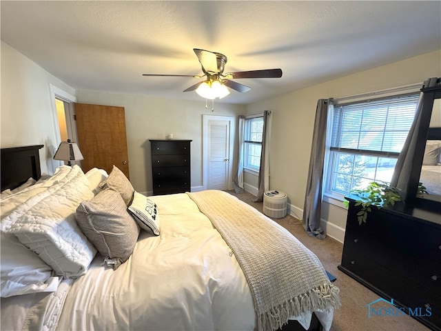 bedroom with a ceiling fan, baseboards, and carpet floors