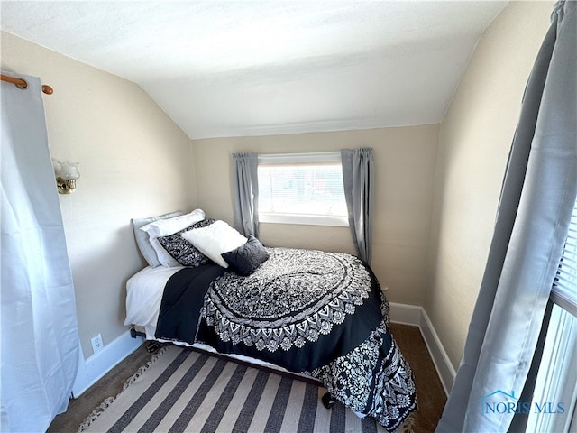 bedroom featuring lofted ceiling and baseboards