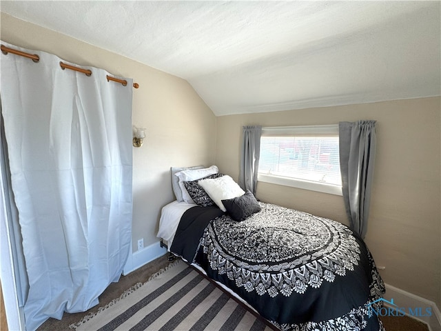 bedroom featuring baseboards and vaulted ceiling