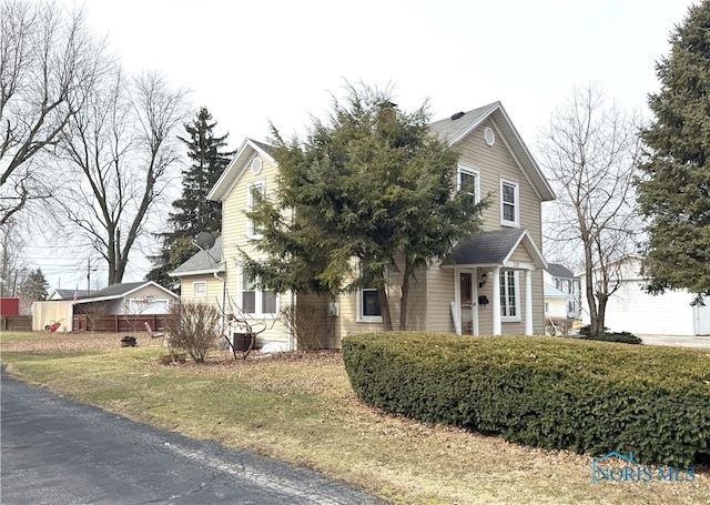 view of property hidden behind natural elements featuring roof with shingles