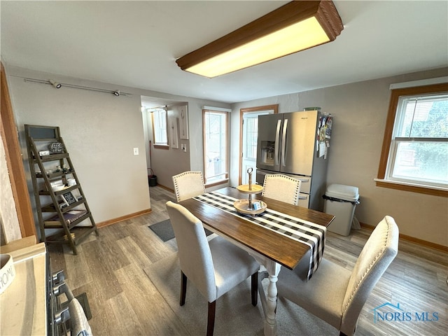 dining area with light wood-style flooring and baseboards