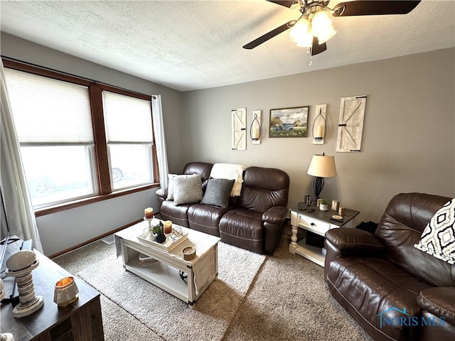 living room featuring a textured ceiling, a ceiling fan, baseboards, and carpet floors