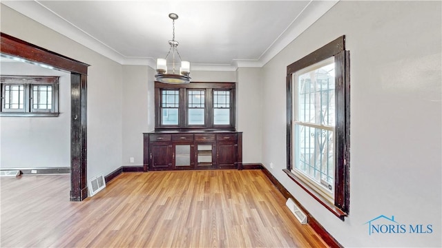 interior space featuring a healthy amount of sunlight, visible vents, and light wood finished floors