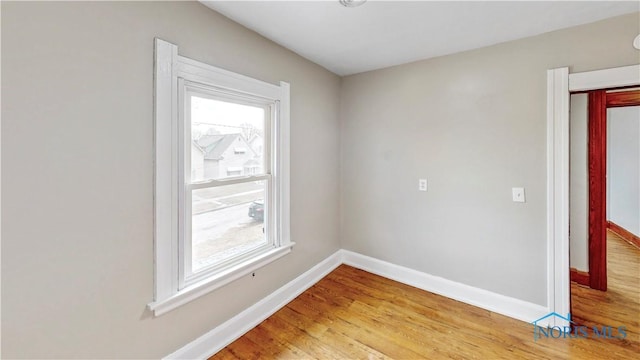 unfurnished room with baseboards and light wood-type flooring