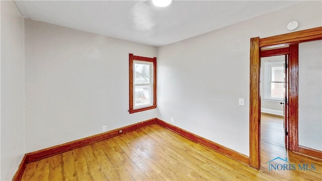 empty room with baseboards and light wood-style floors