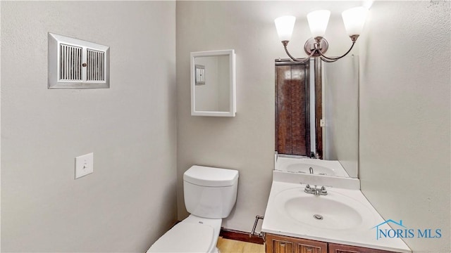 bathroom featuring vanity, toilet, and visible vents