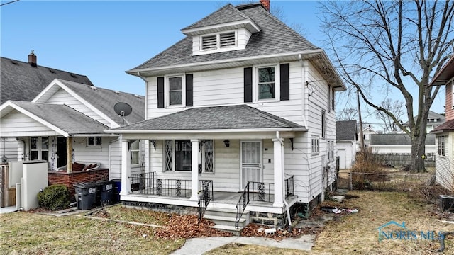 american foursquare style home with a porch, fence, roof with shingles, and a chimney