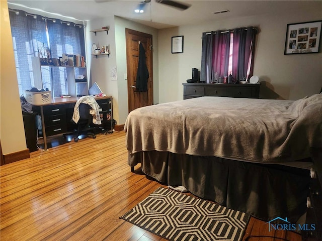 bedroom featuring visible vents, baseboards, and wood finished floors