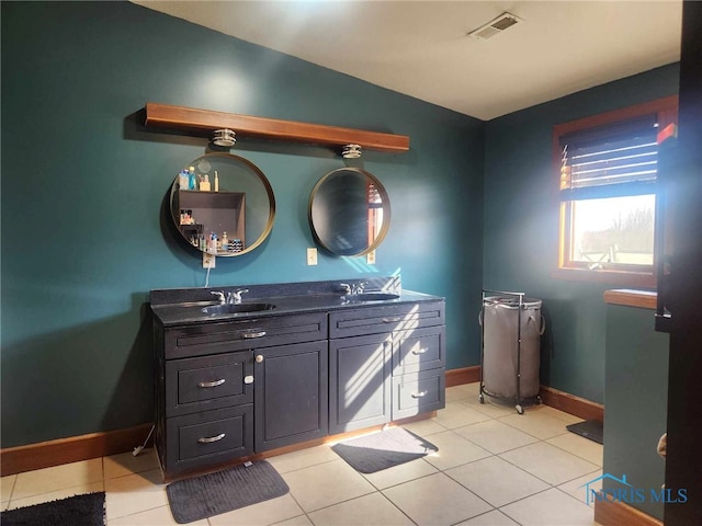 bathroom with a sink, visible vents, double vanity, and tile patterned floors