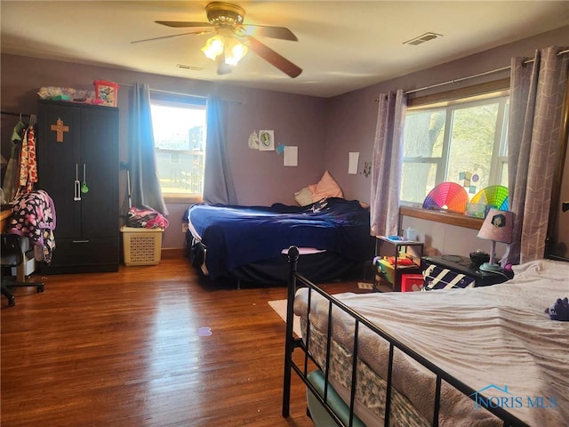 bedroom featuring visible vents, ceiling fan, and wood finished floors