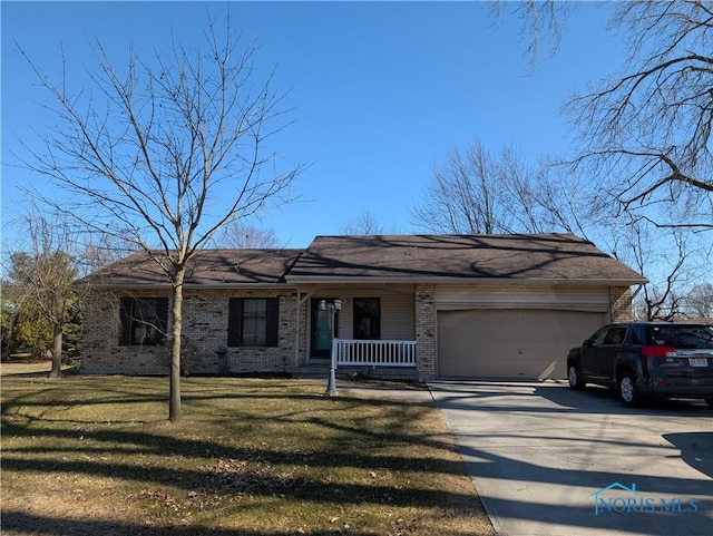 ranch-style home featuring driveway, a porch, a front yard, a garage, and brick siding