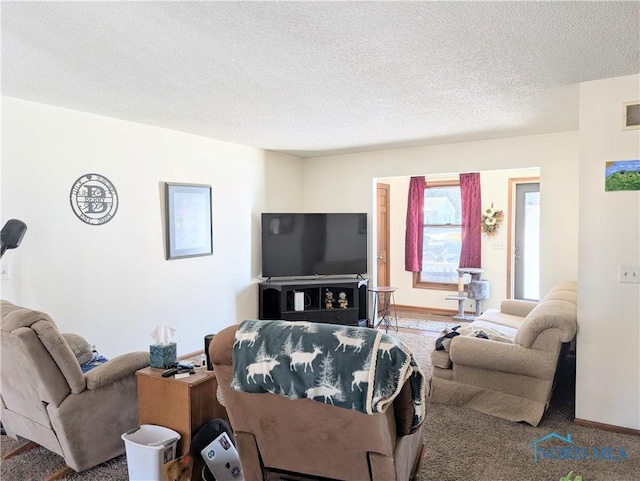 living area with baseboards, visible vents, and a textured ceiling