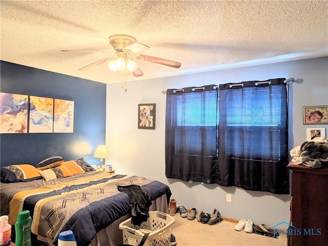 carpeted bedroom featuring a textured ceiling and a ceiling fan