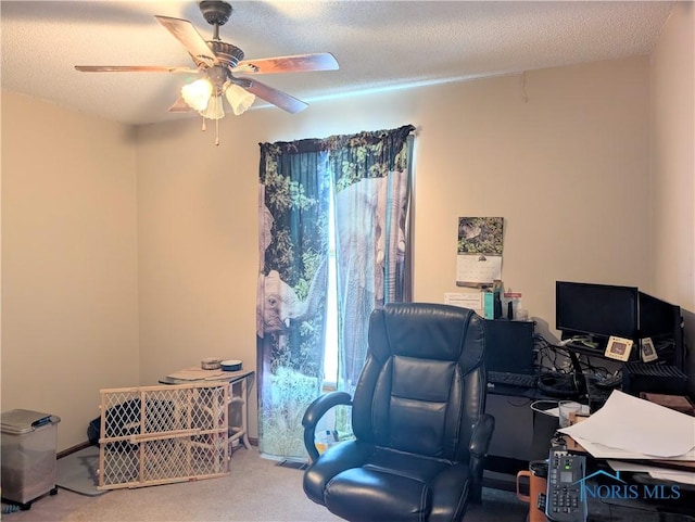 carpeted office featuring baseboards, a textured ceiling, and a ceiling fan