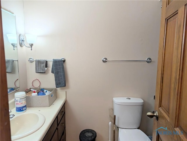 half bathroom with vanity and toilet