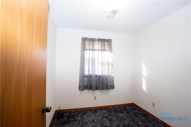 carpeted spare room featuring baseboards