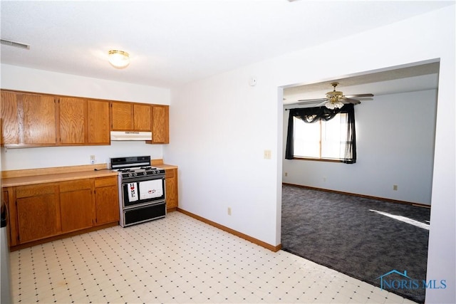 kitchen with brown cabinetry, range with gas stovetop, under cabinet range hood, and visible vents
