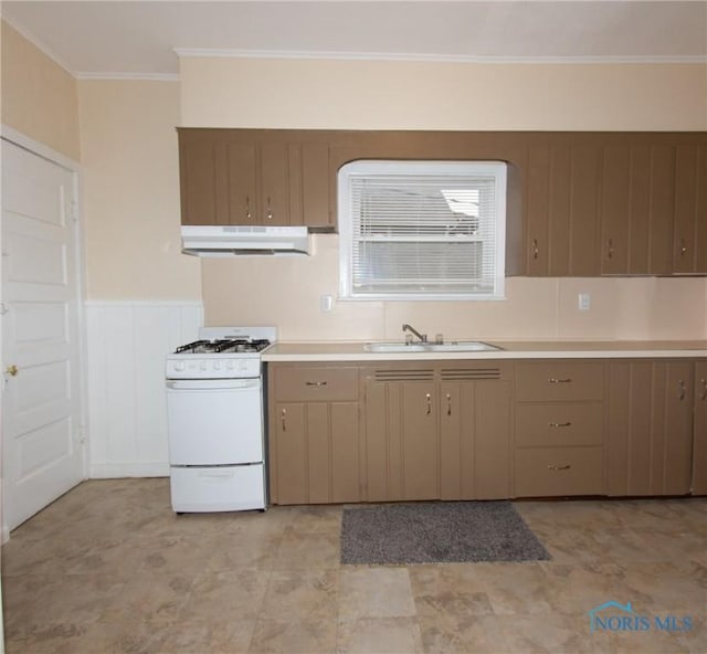 kitchen with under cabinet range hood, white range with gas cooktop, light countertops, and a sink