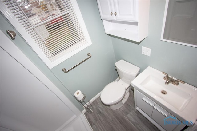 bathroom with vanity, toilet, and wood finished floors