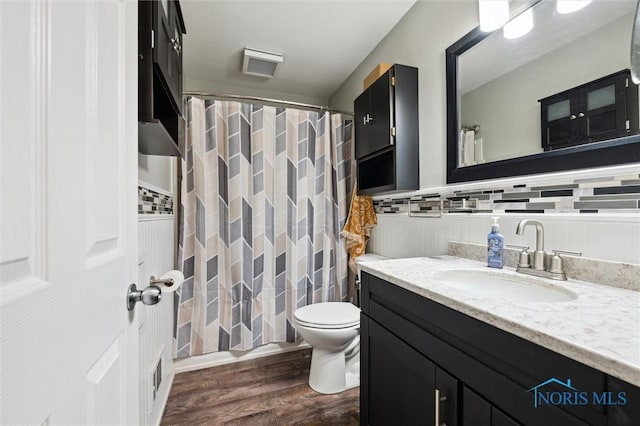 bathroom featuring a shower with shower curtain, toilet, vanity, and wood finished floors