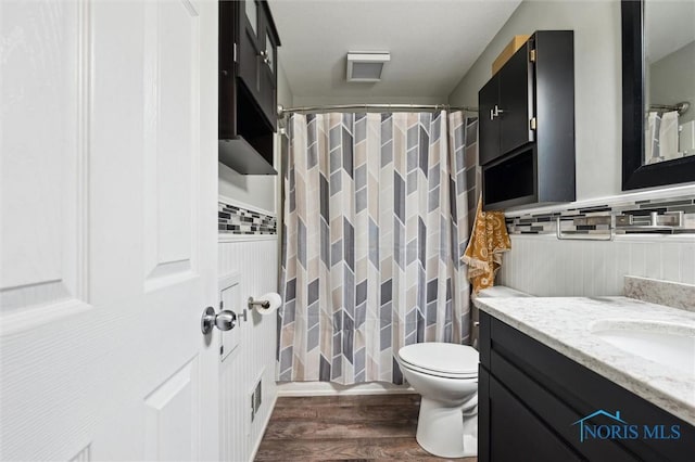 full bathroom featuring a shower with curtain, toilet, wood finished floors, and vanity