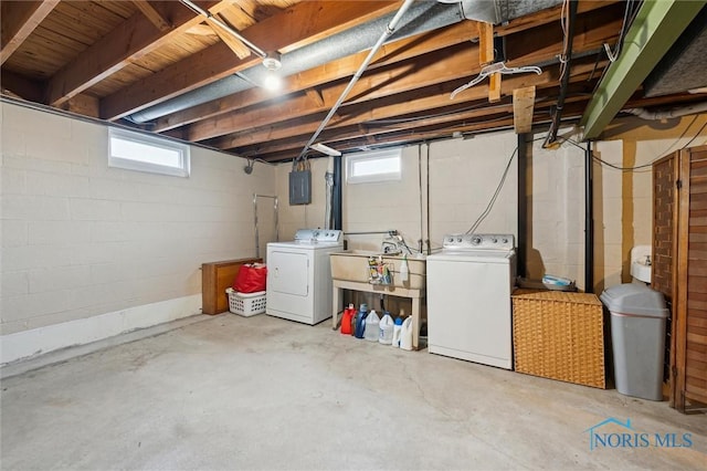 below grade area featuring electric panel, independent washer and dryer, and a sink