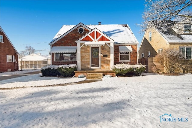 bungalow-style house with brick siding and stone siding