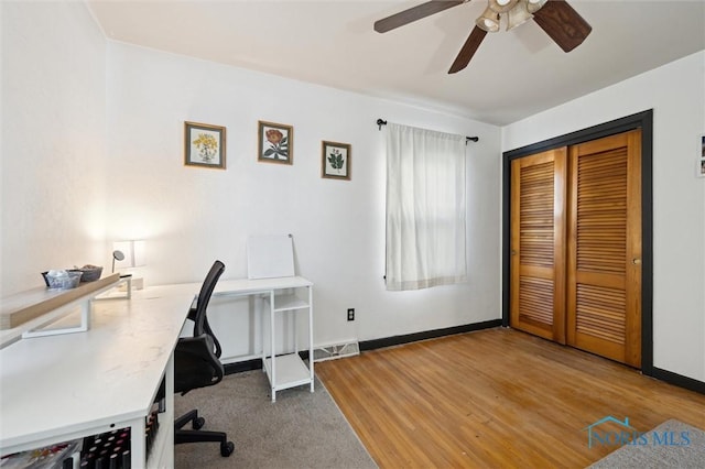 home office featuring visible vents, wood finished floors, baseboards, and ceiling fan