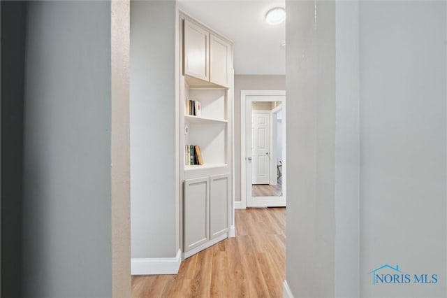 hall featuring light wood-style floors and baseboards