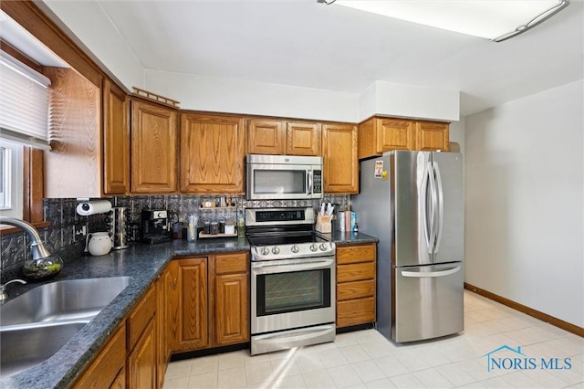 kitchen featuring a sink, stainless steel appliances, and brown cabinets