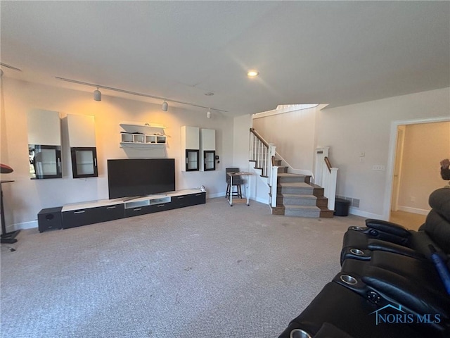 carpeted living room featuring track lighting, stairway, and baseboards